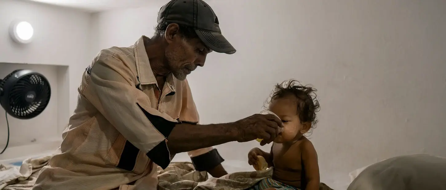 Father giving a child a drink