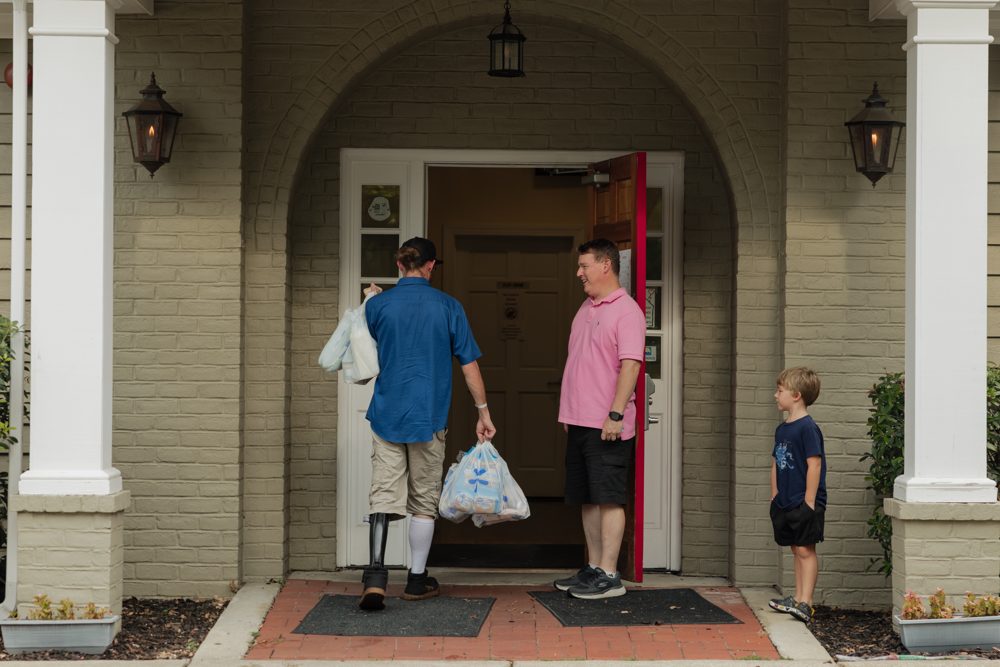 Donors dropping off supplies at the front door of the House