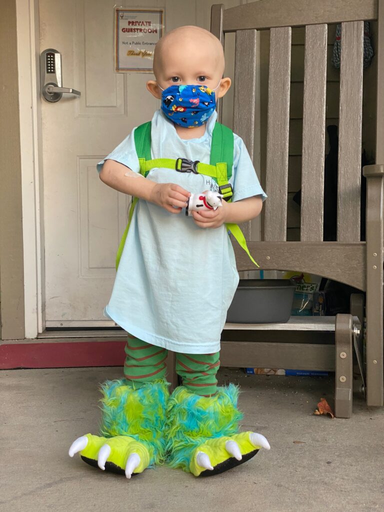 Claude posing in large, fuzzy monster shoes.