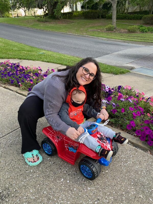Juanita poses with Claud outside with a toy four wheeler.