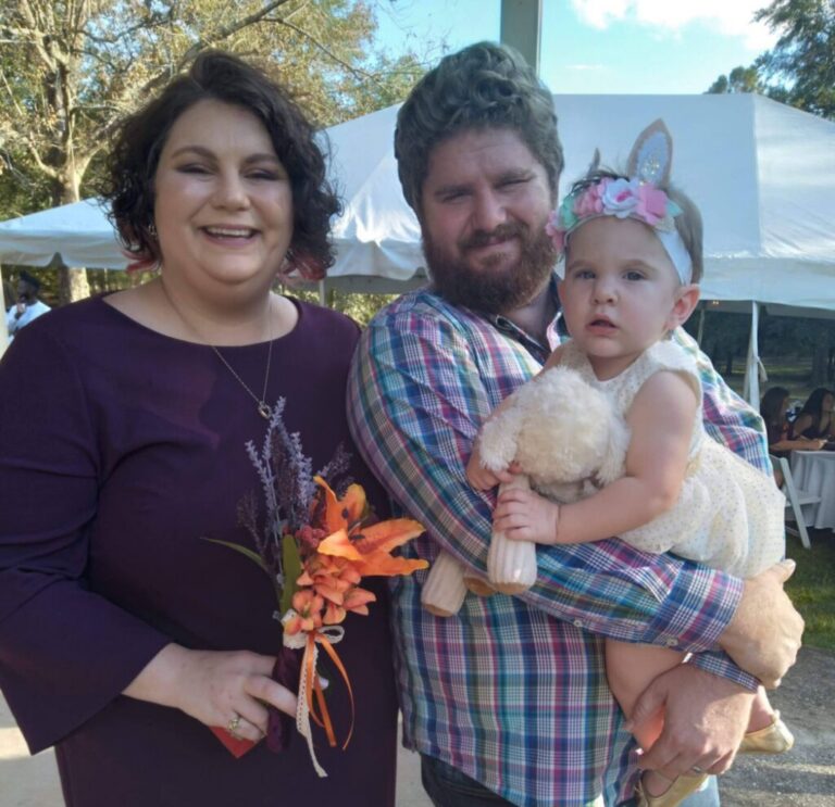 The Paden family posing with Eva at an outdoor market in the fall.